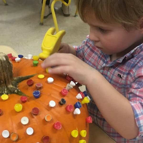 First Congo Preschooler decorating a pumpkin