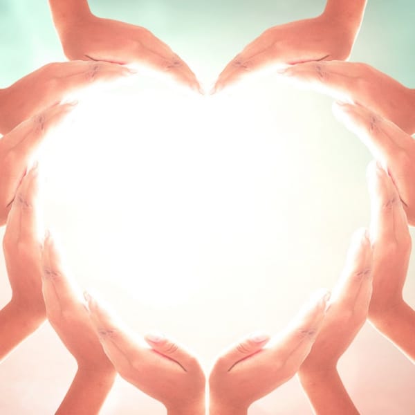 Multiple hands forming the shape of a heart