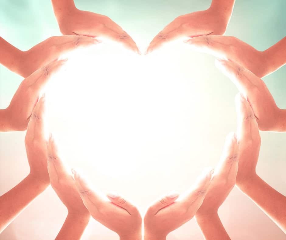 Multiple hands forming the shape of a heart