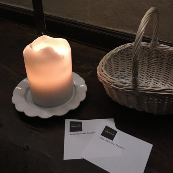 A lit candle on a table with notecards