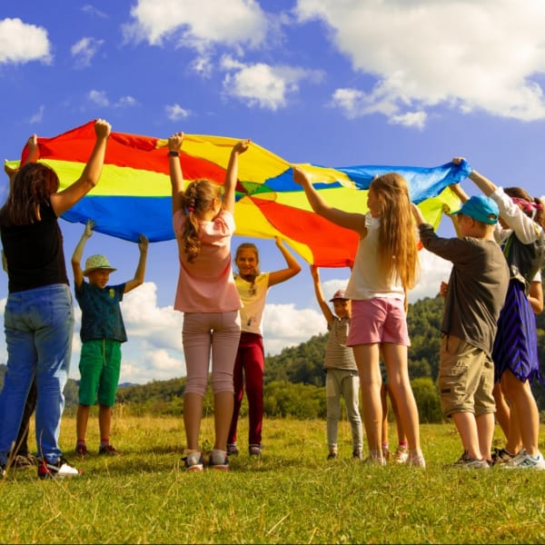 Kids playing with a huge kite outside