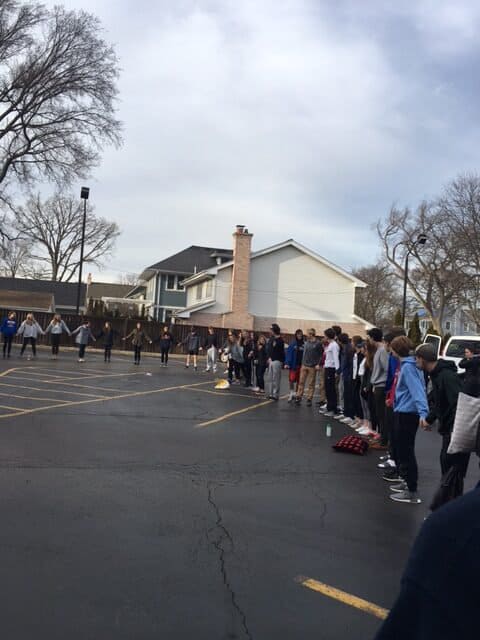 Youth program kids holding hands in a parking lot