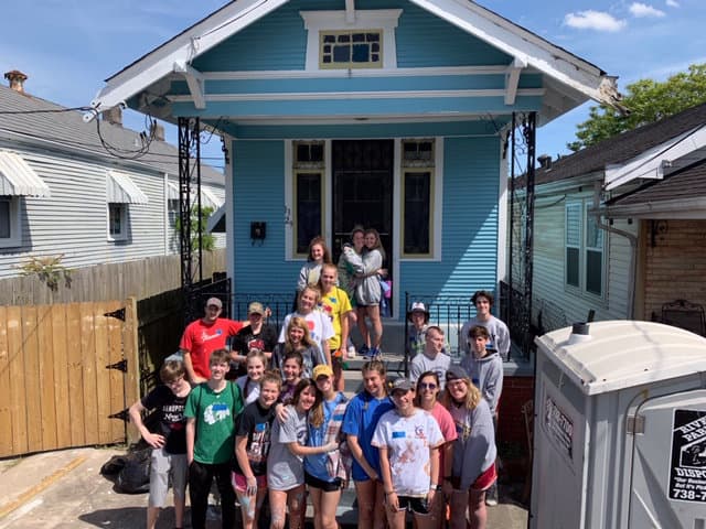 Youth program kids standing outside of a house